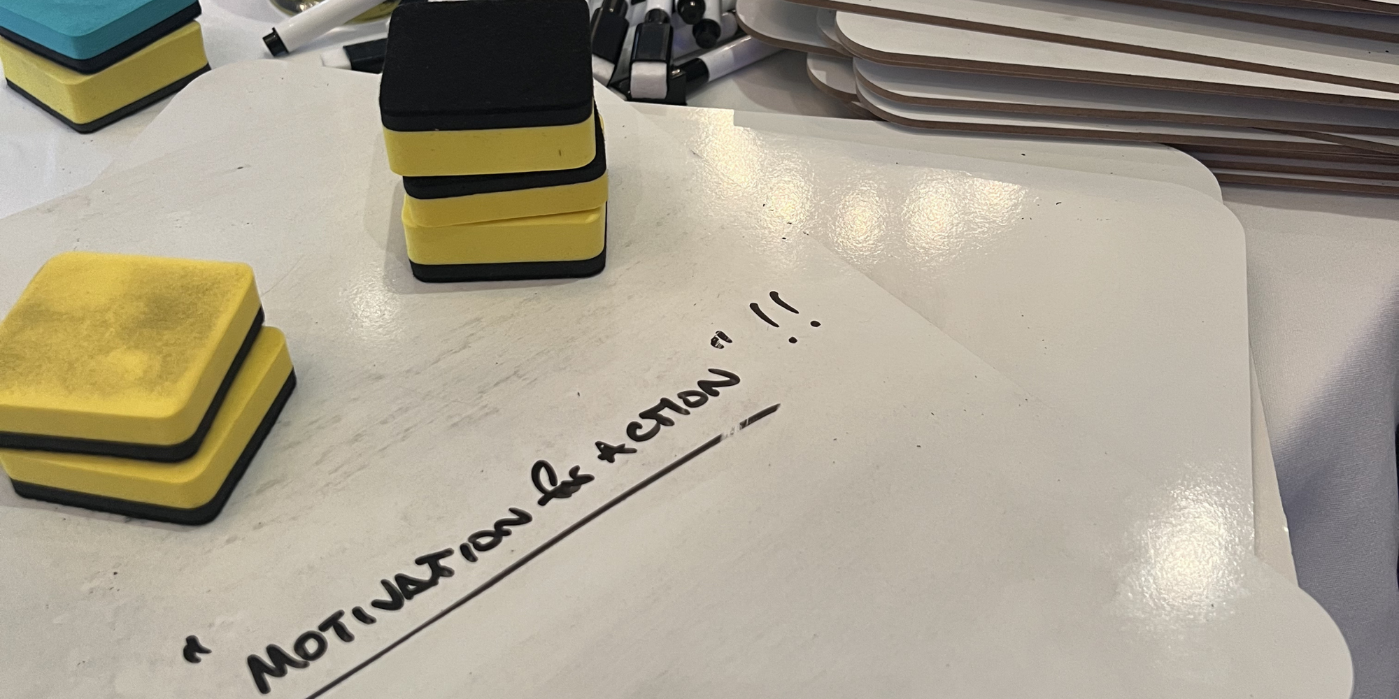 Whiteboard with "motivation for action" written on it in black marker