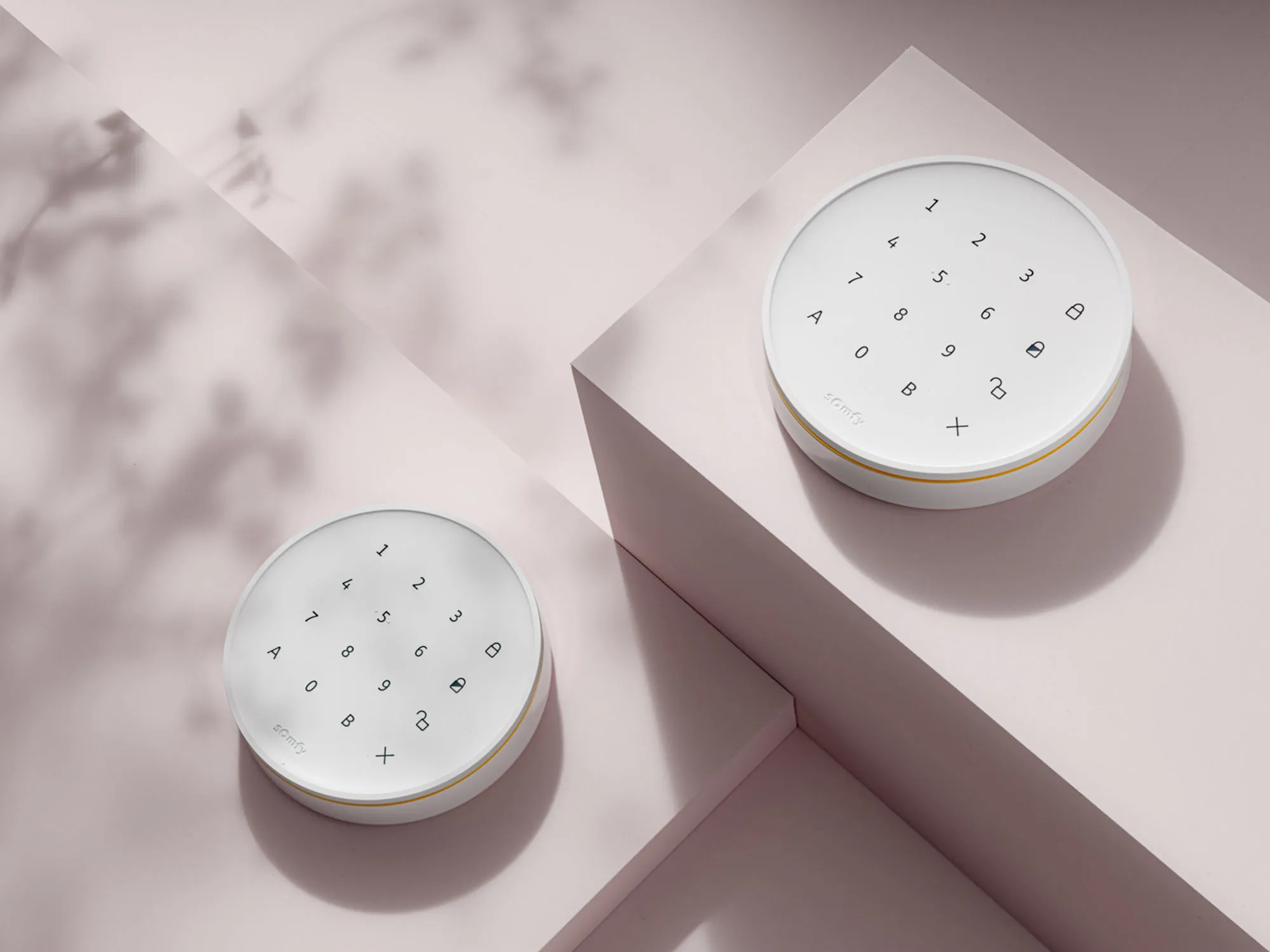 photo still life packshot alarme somfy clavier sur fond rose