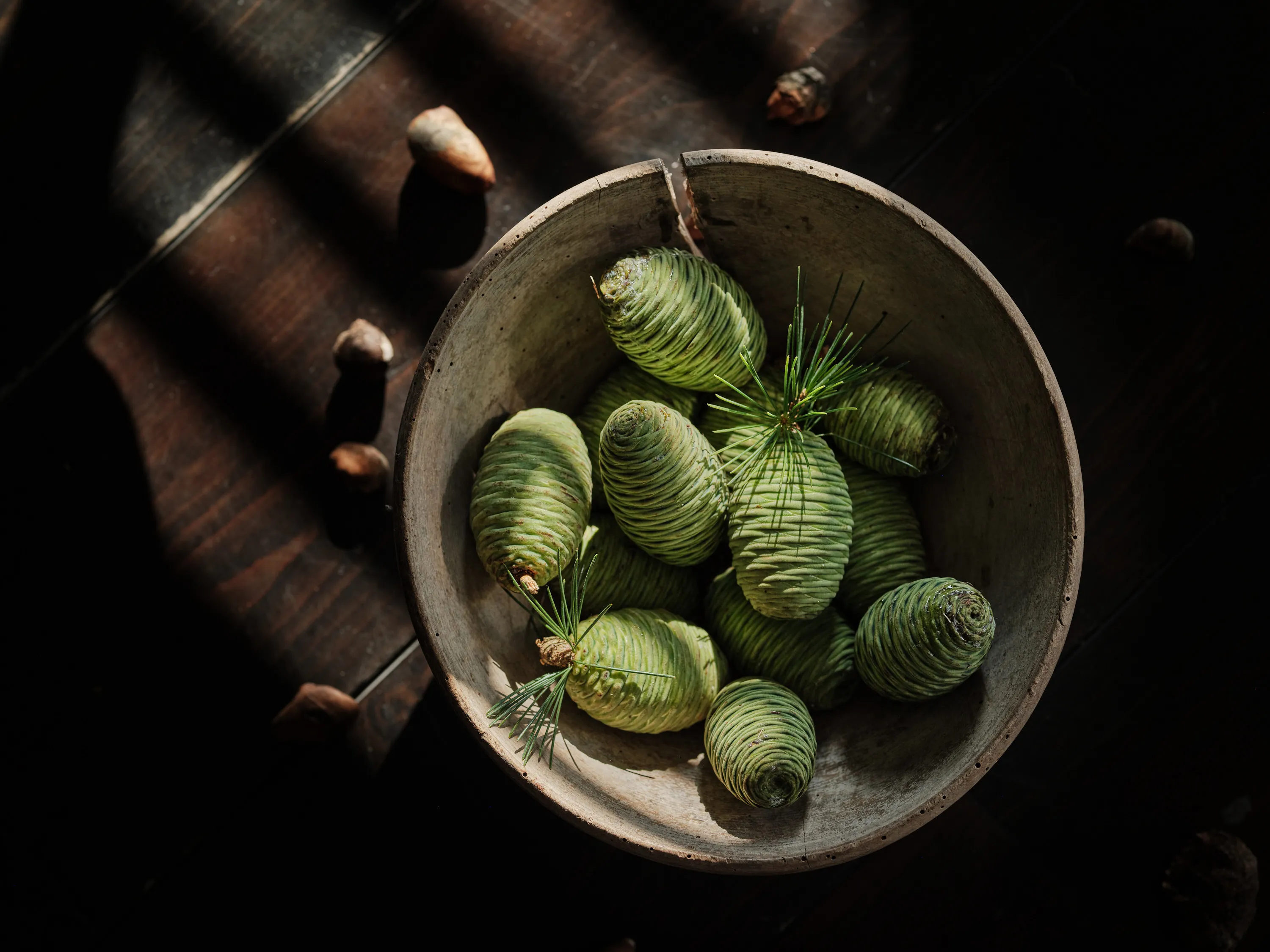 still life pommes de pin vertes posées sur une table