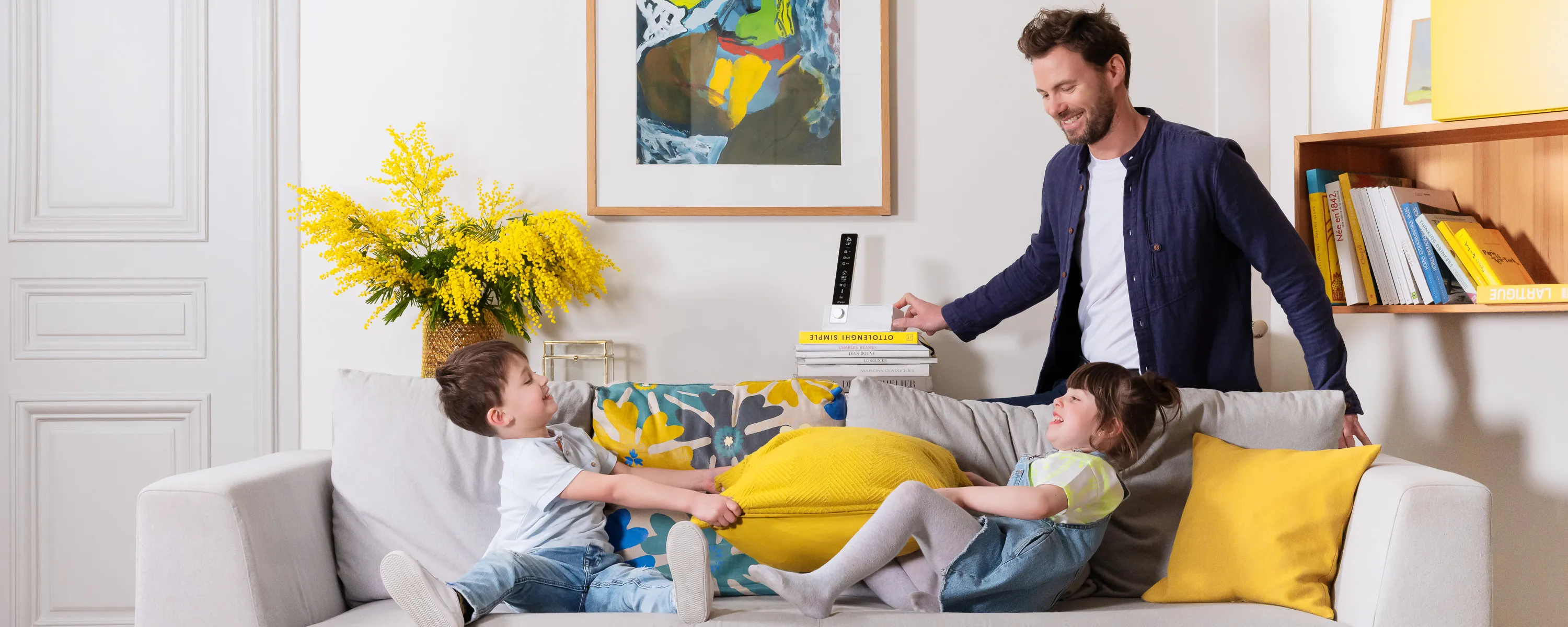 visuek lifestyle pour sowee station connectée dans un salon jaune avec un père et ses enfants