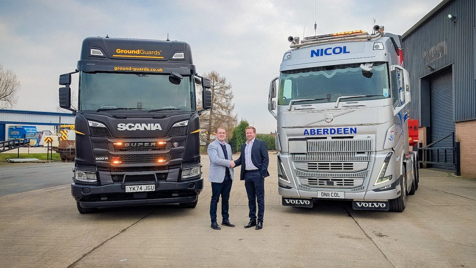 GroundGuards and Nicol of Skene Shaking hands in official partnership with both company lorries in the back. Nicol of Skene  is the Official Distributor for Scotland and Beyond. 