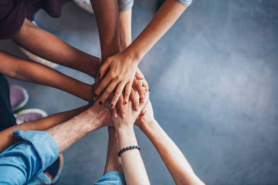 10 hands joining together as a sign of community