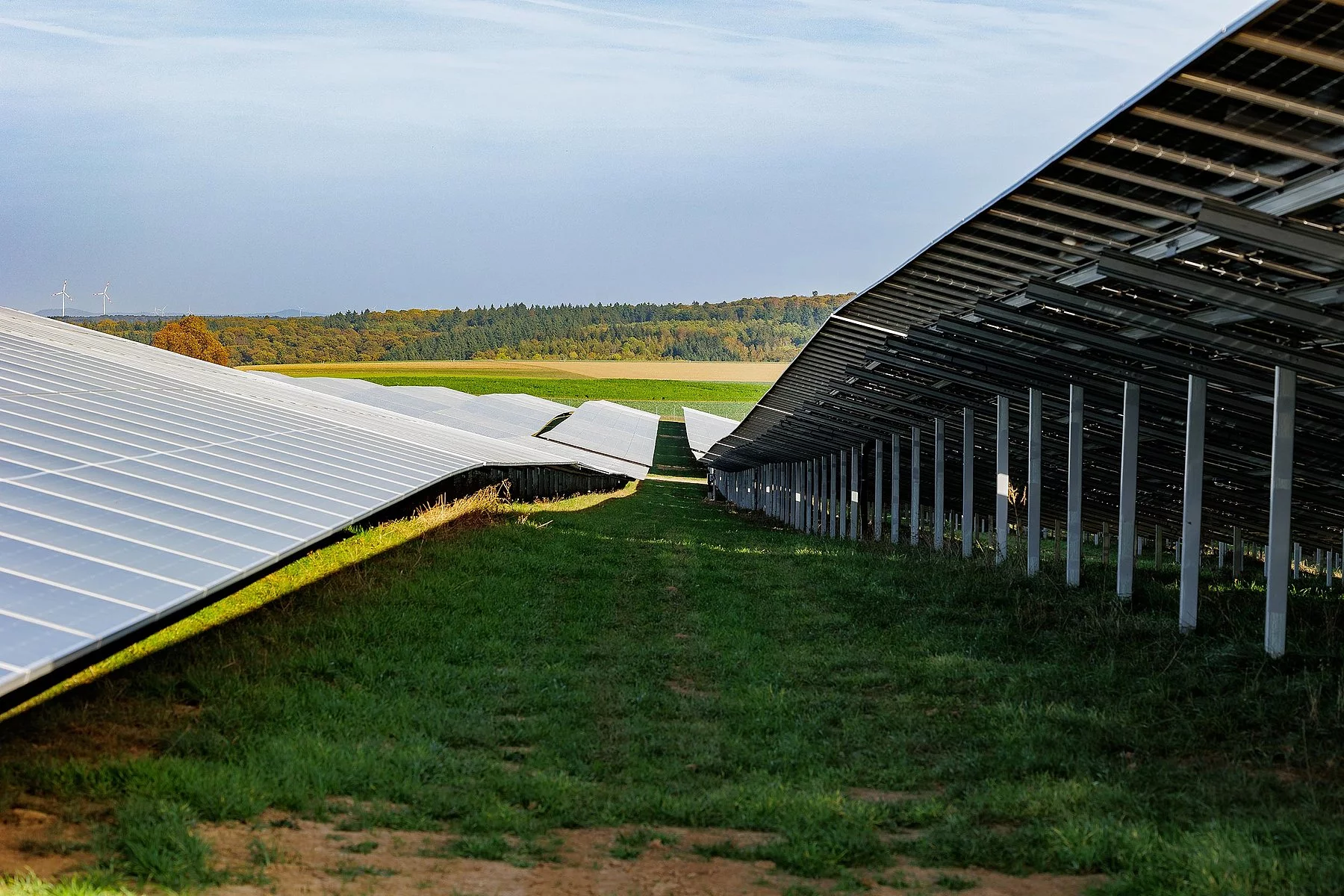 Solarpark mit Photovoltaik-Modulen in der Landschaft, seitliche Perspektive