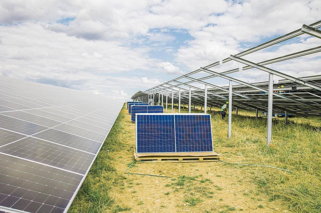 Montage von Solarmodulen auf Gestellen, Arbeiter bei Installation