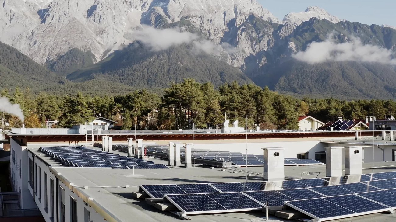 Luftaufnahme des Pflegeheims Mieming mit installierter Photovoltaikanlage in alpiner Umgebung