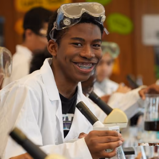 Student in lab coat experimenting