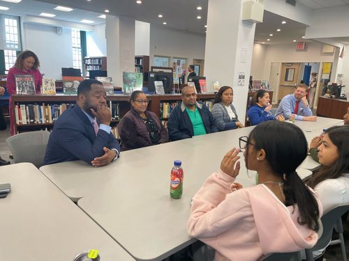 Students and adults discussing in library