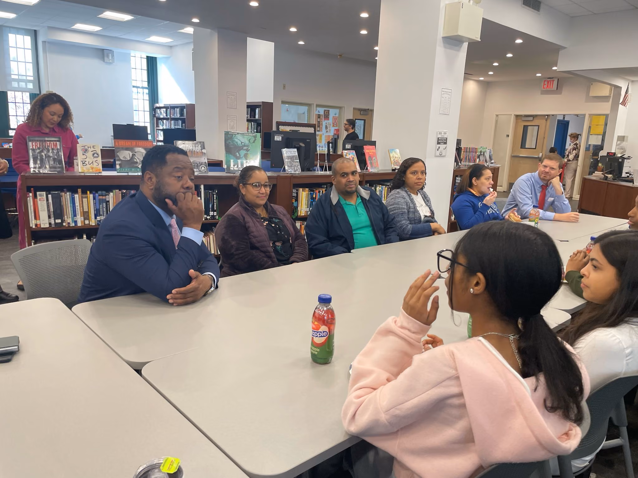 Students and adults discussing in library