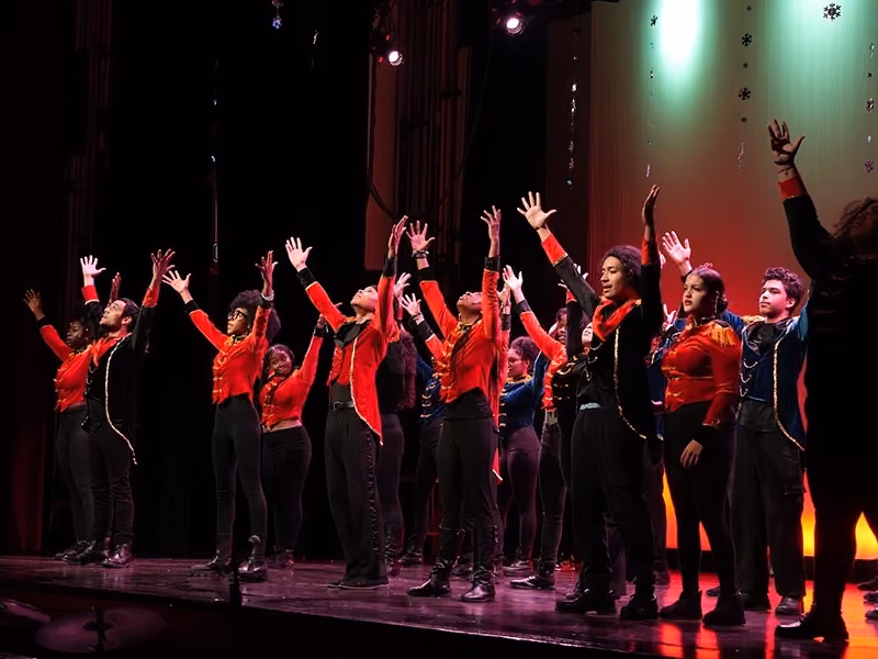Performers on stage in red and black