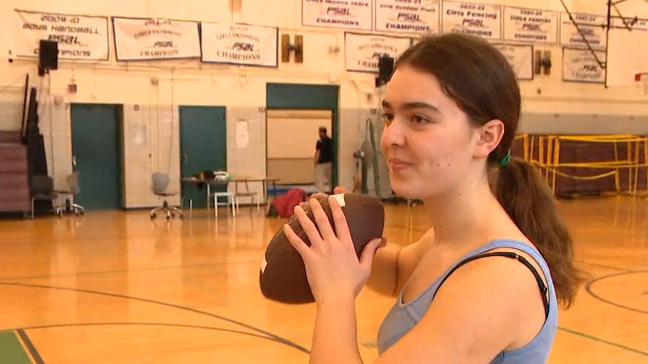 Student holding football indoors