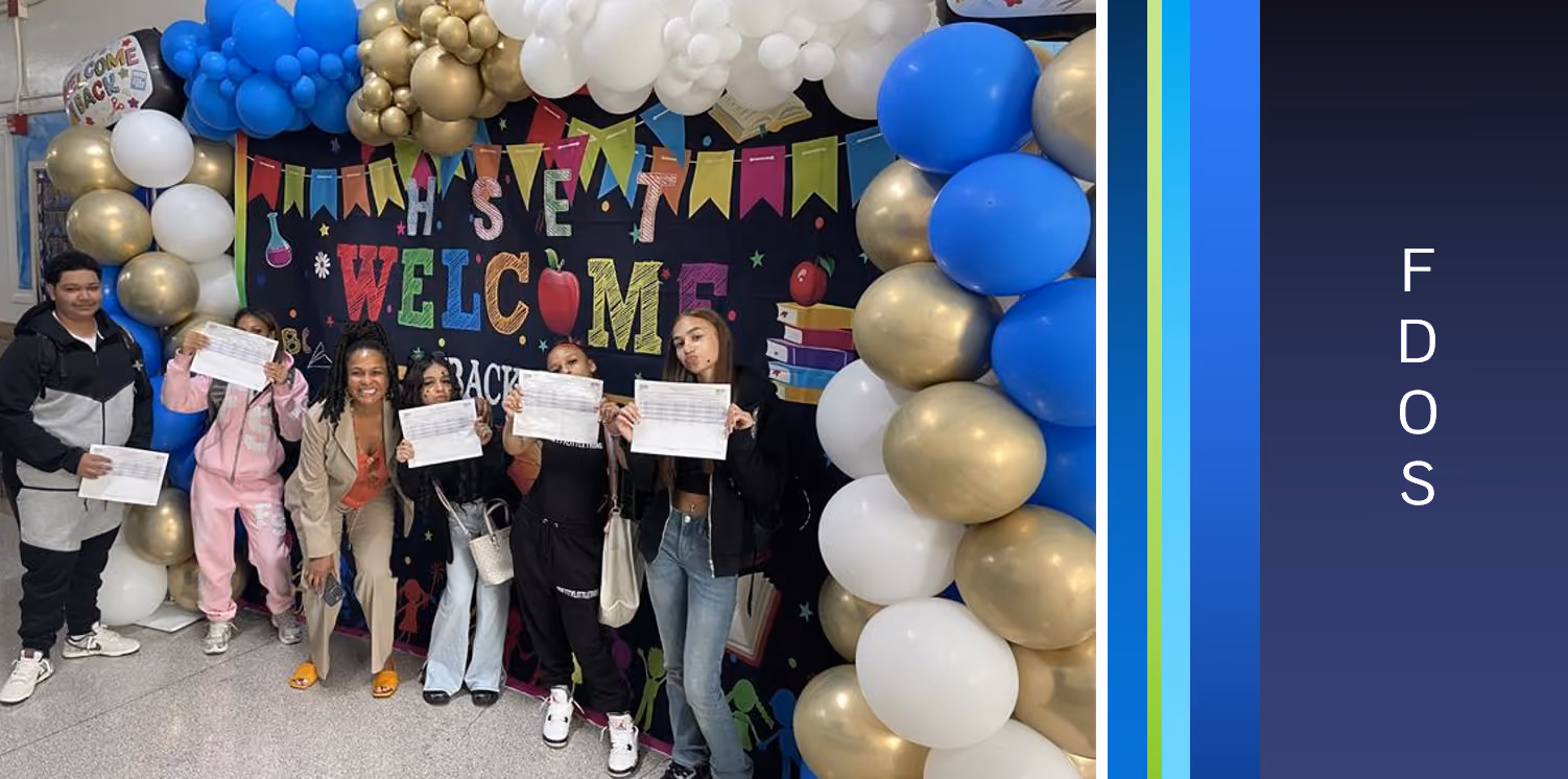 Students holding schedules under Welcome Back balloon arch on first day