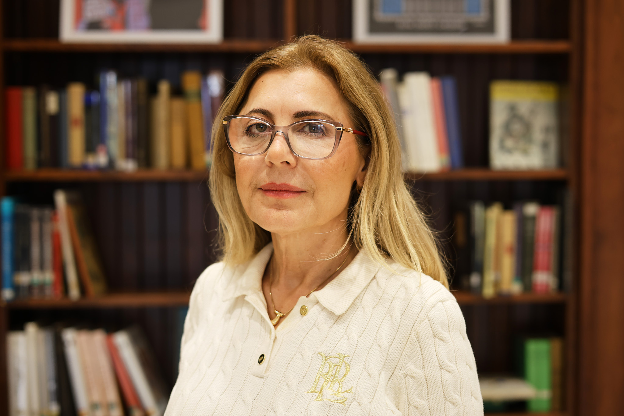 Anita Bushi posed in front of a bookshelf