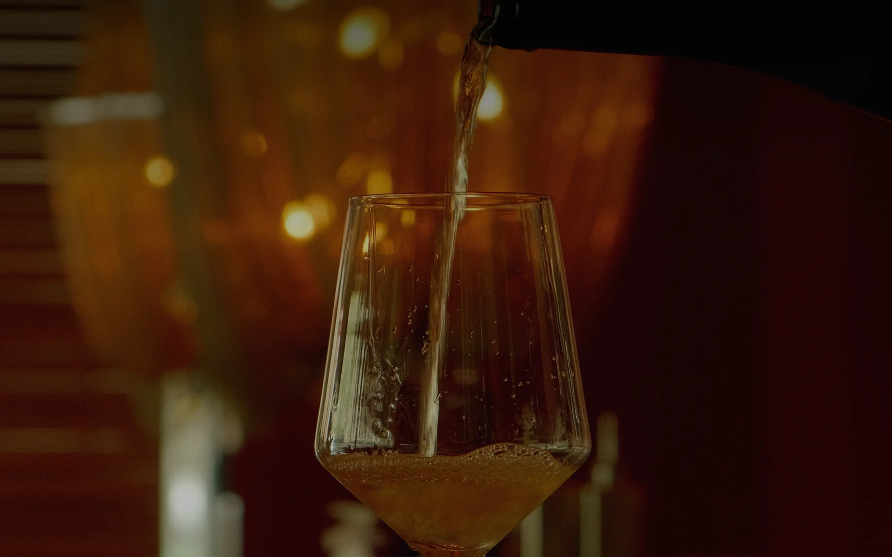 Wein wird aus einer Flasche in ein Glas gegossen