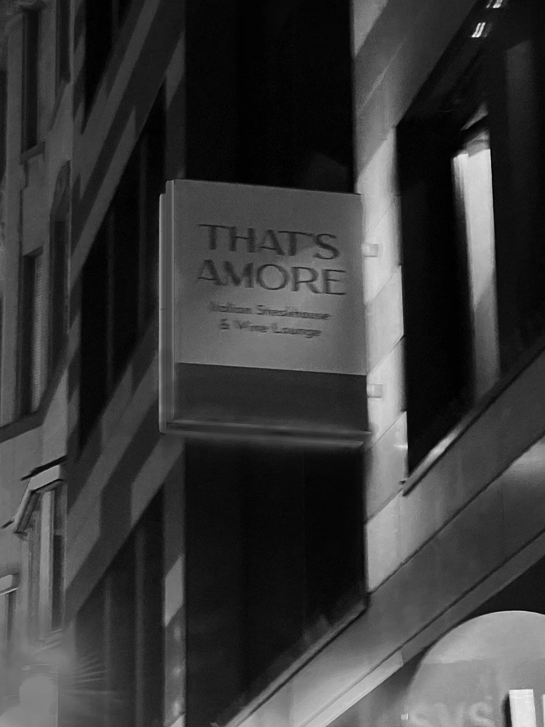 Leuchtschild an einer Hausfassade mit der Aufschrift ‘That’s Amore – Italian Steakhouse & Wine Lounge’.