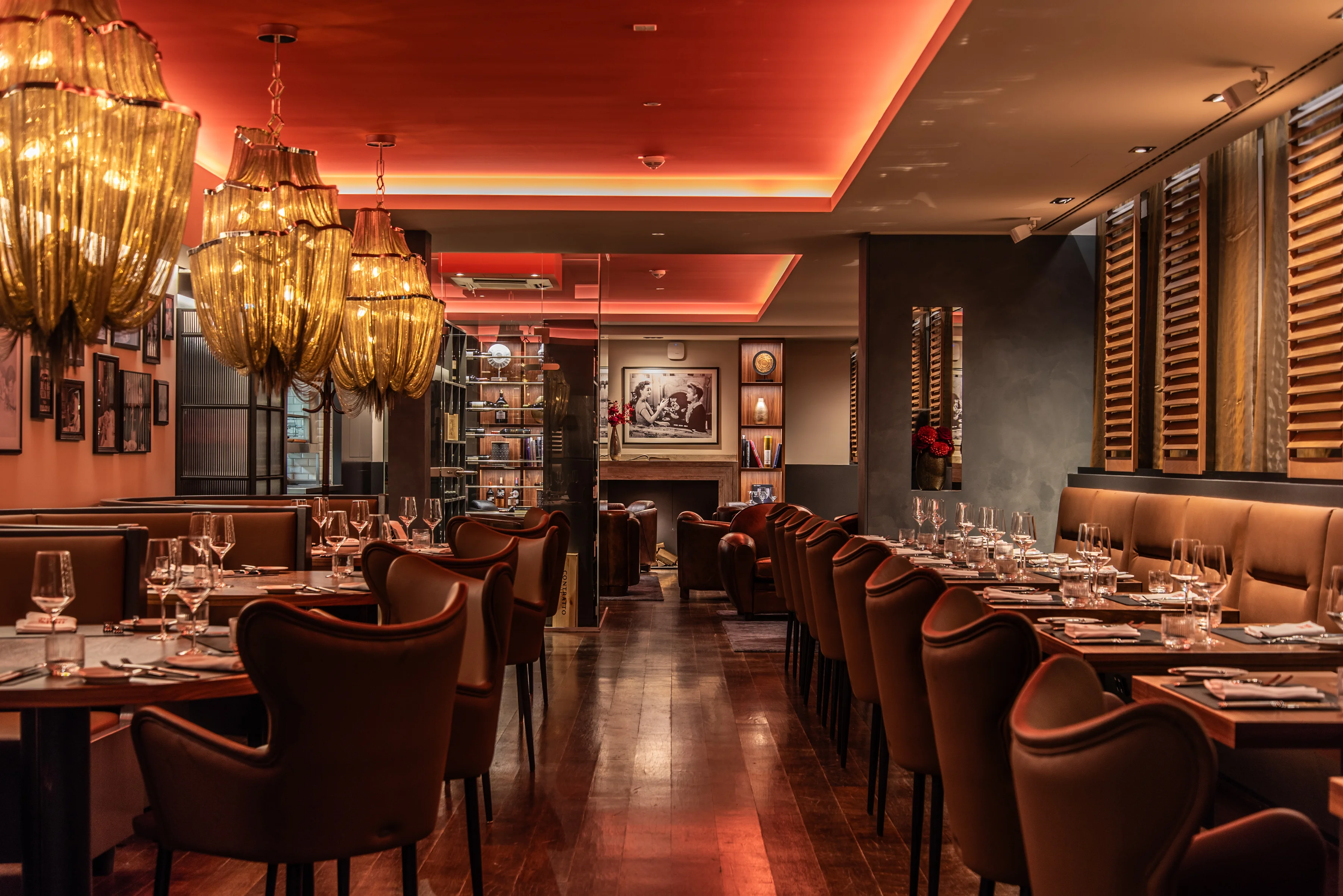 Stimmungsvoll beleuchteter Innenraum eines Restaurants mit elegant gedeckten Tischen, warmem Licht und gemütlicher Atmosphäre.