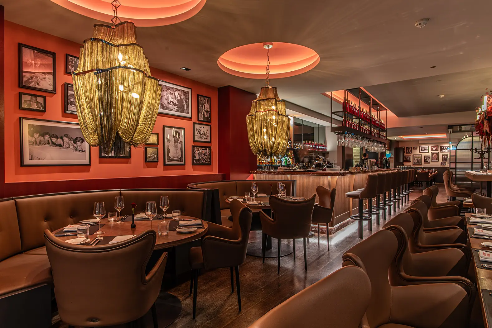 Stimmungsvoll beleuchteter Innenraum eines Restaurants mit elegant gedeckten Tischen, warmem Licht und gemütlicher Atmosphäre.