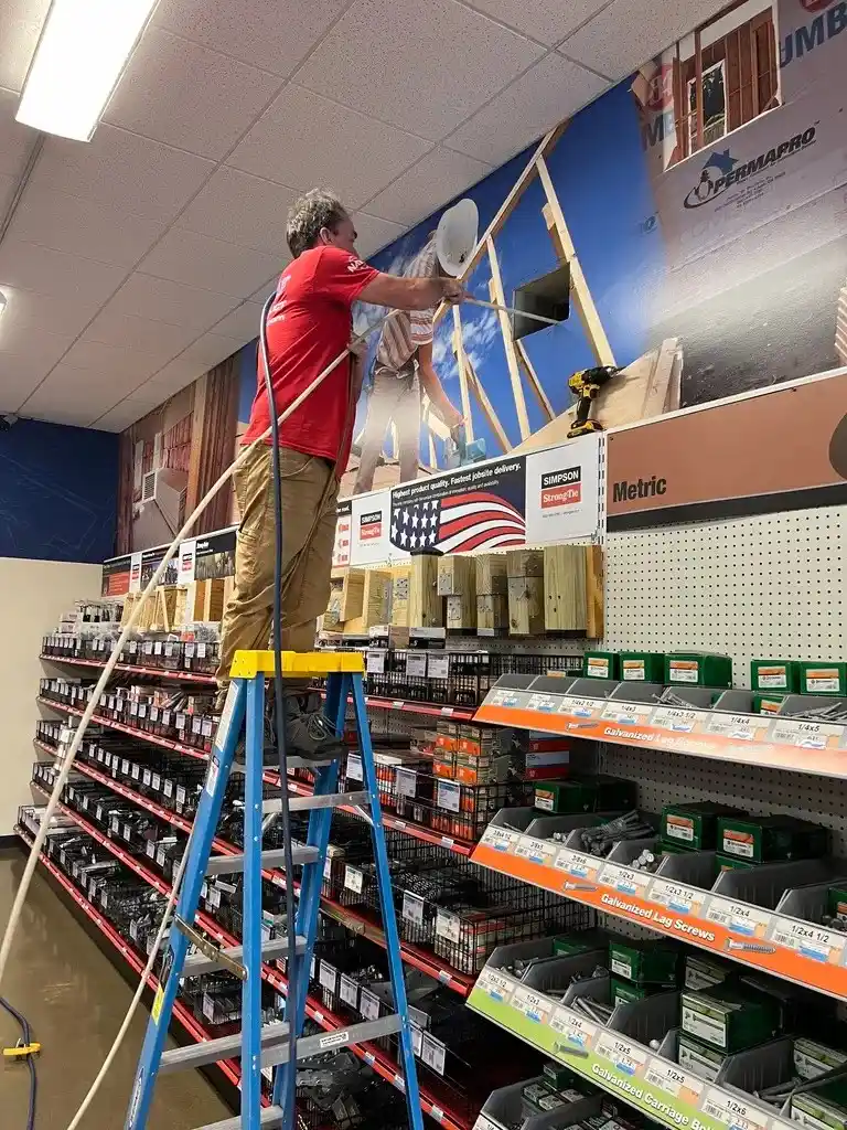 Person on ladder in hardware store working near ceiling
