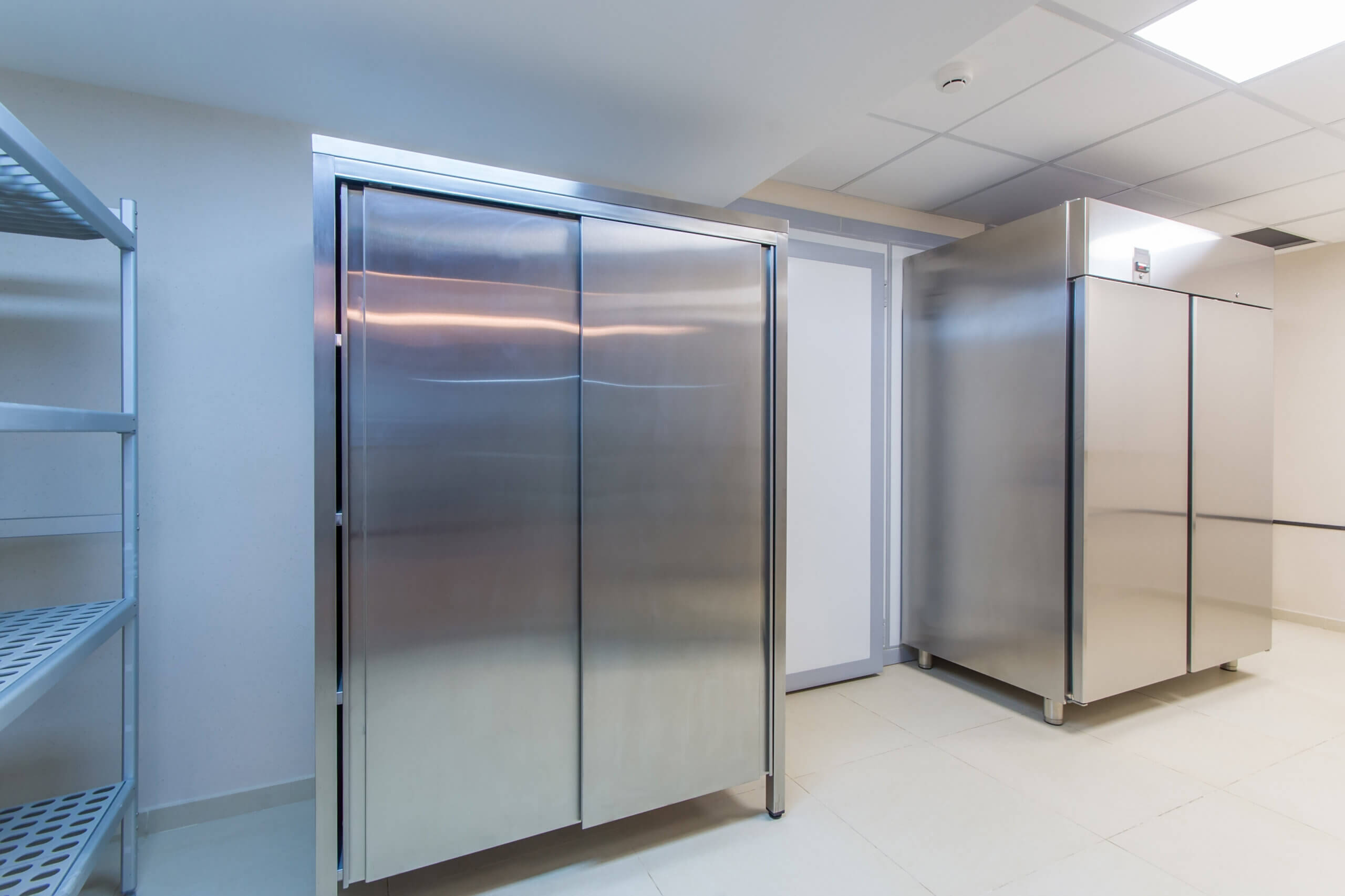 The image displays commercial refrigeration equipment, specifically a walk-in refrigerator and another type of commercial refrigerator, likely a reach-in unit.