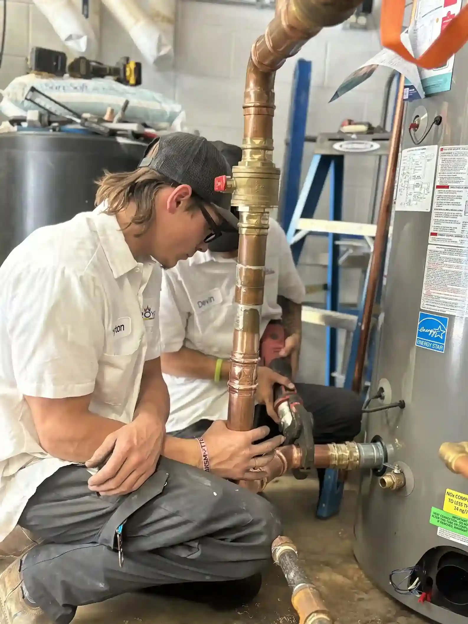 Fontanero de emergencia reparando un calentador de agua con fugas