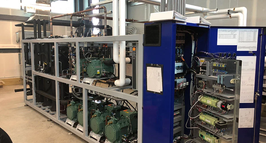 Technicians maintaining indoor commercial HVAC systems.