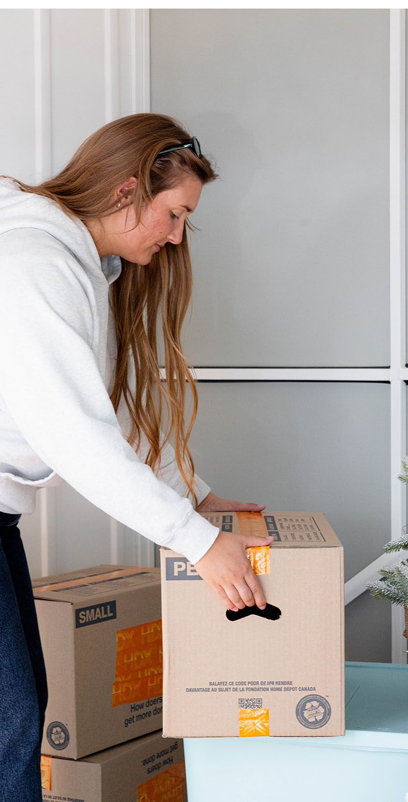 girl picking up a box to go into her storage unit