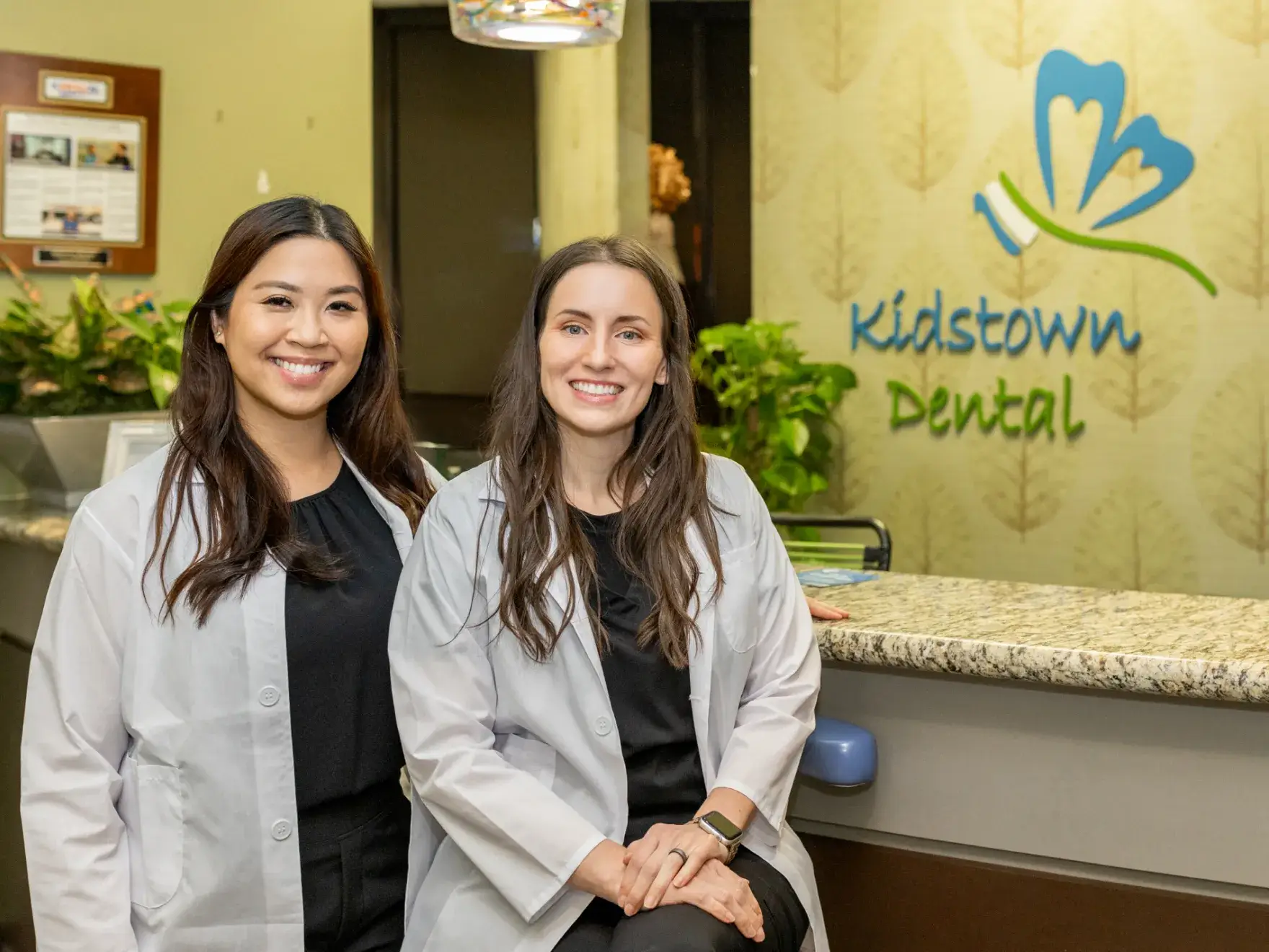 Dr. Fillmore and Dr. Siripon sitting at a counter in a dental office.
