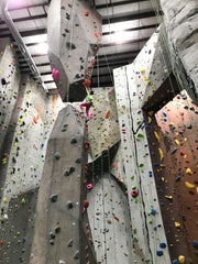 A woman prepares to climb up from a stalagmite onto a stalactite.