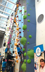 Actor Jason Momoa of Aquaman helps the kids climb during the grand opening