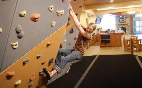 A man climbs on an office bouldering wall