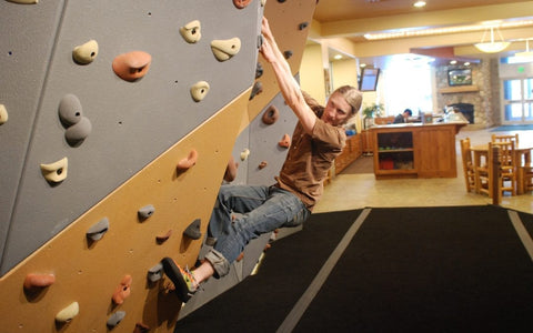 A man climbs on an office bouldering wall