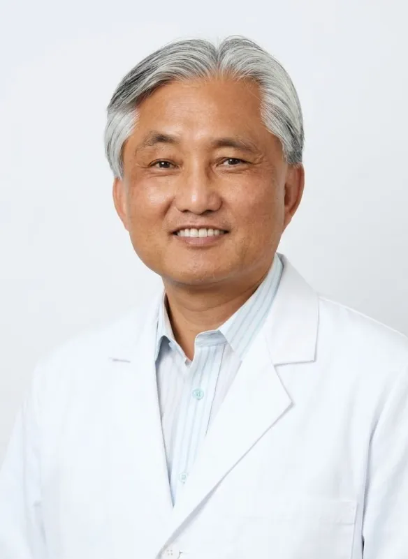 Dr Kevin Yoo with gray hair wearing a white lab coat and light-striped shirt against a plain background.