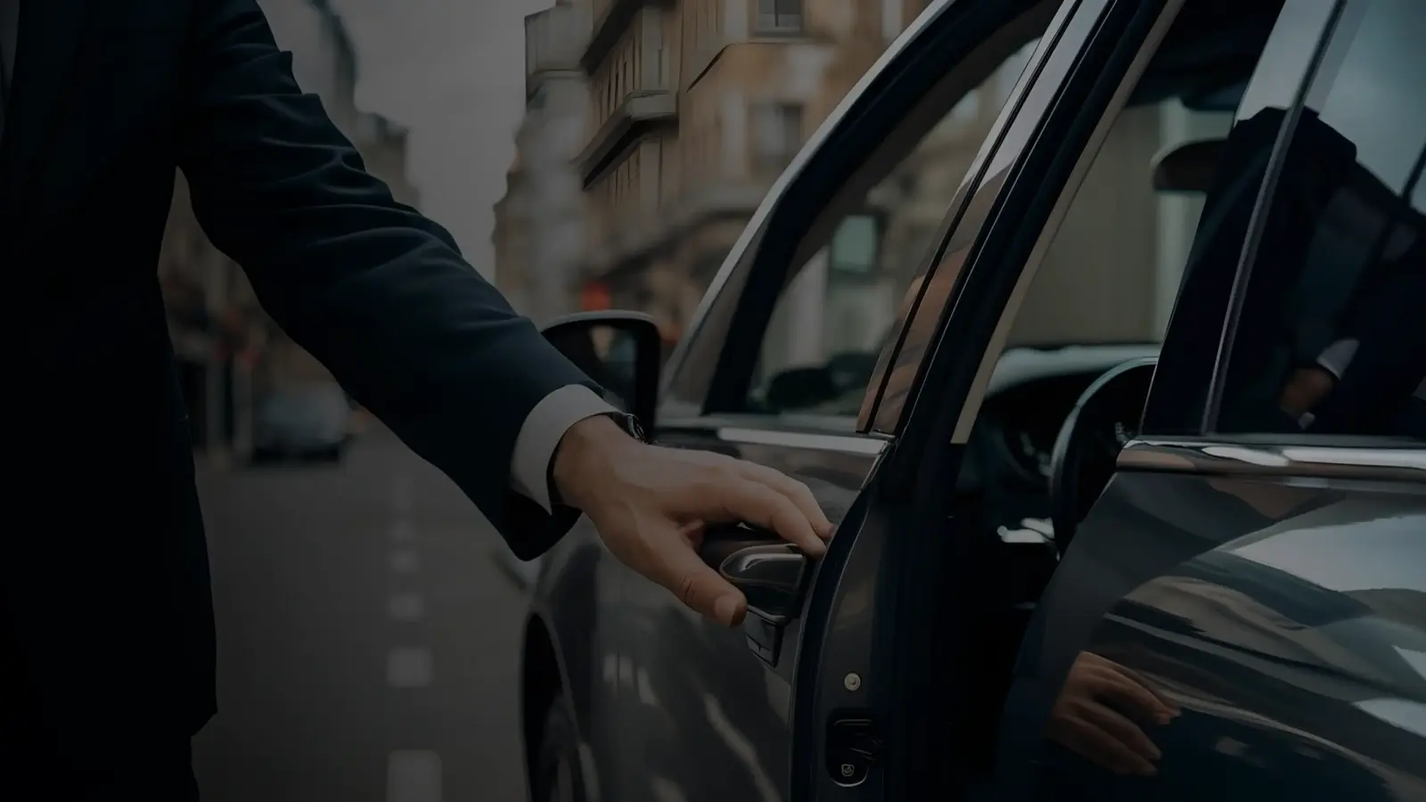 Chauffeur in a black suit opening the door of a luxury car for a client on a city street – professional airport transfer and private car service in Miami