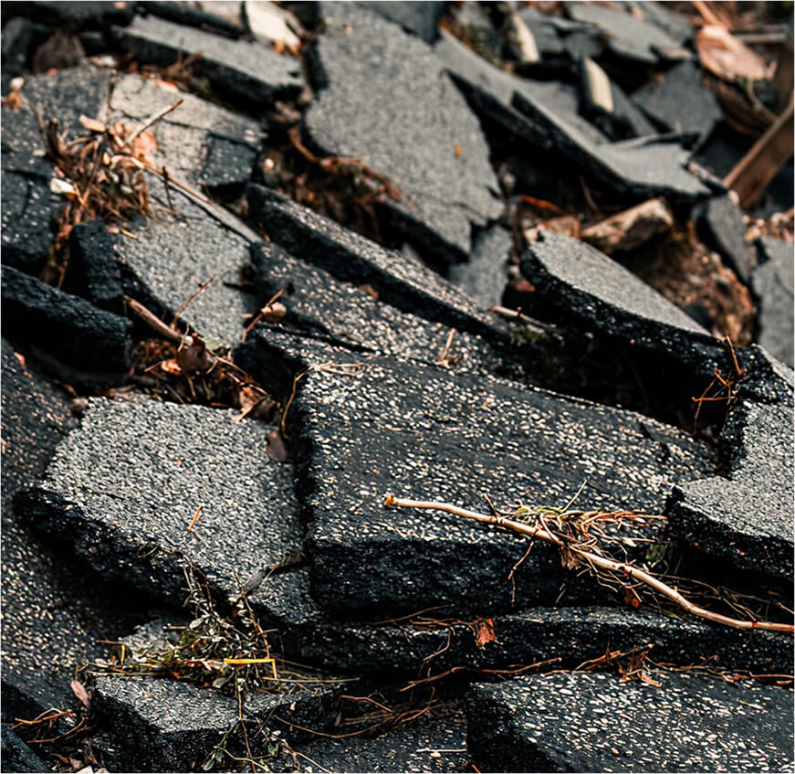 Extremely damaged tar-seal road. 