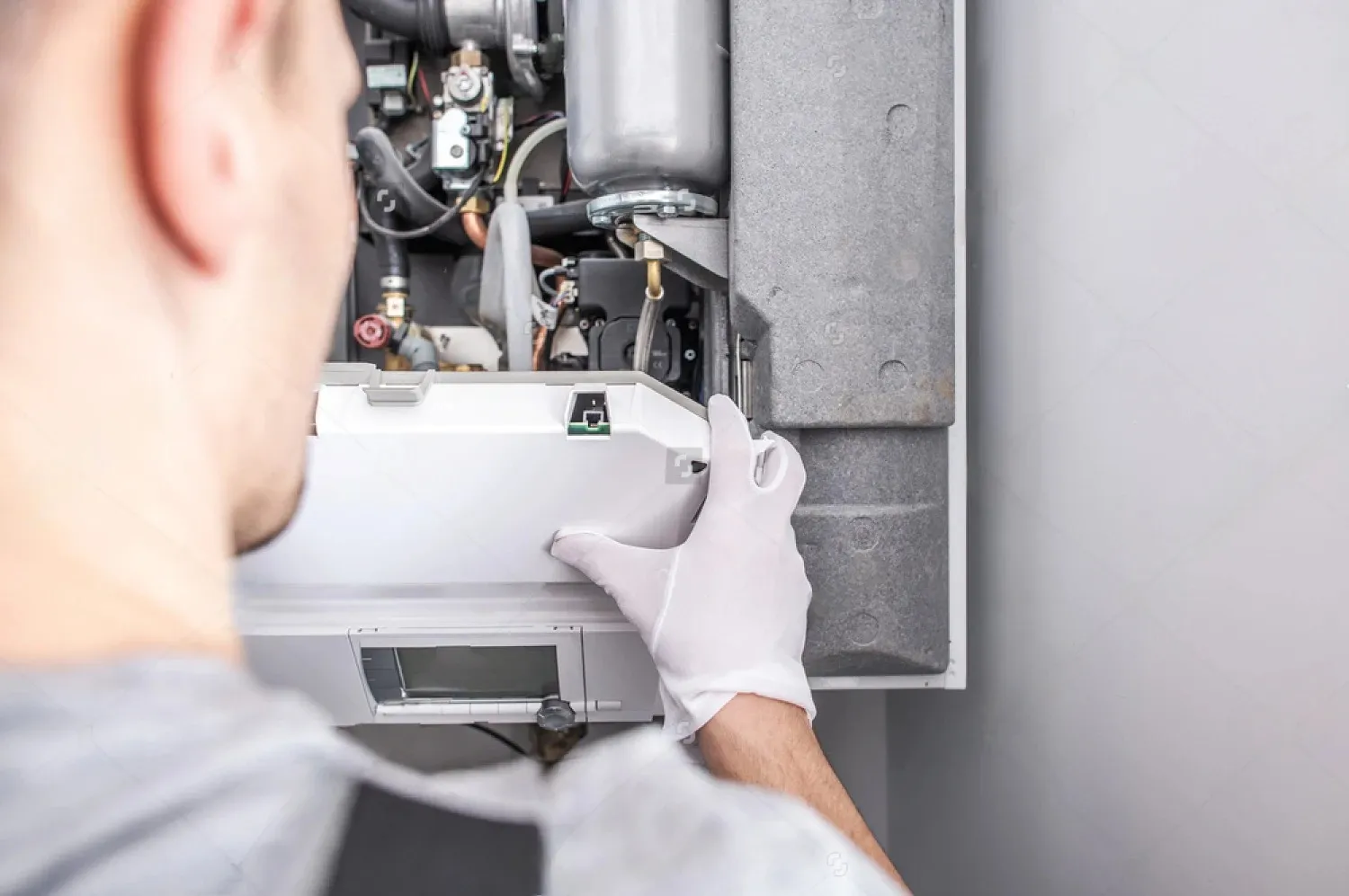 Technician in white gloves repairing an industrial heating or electrical system