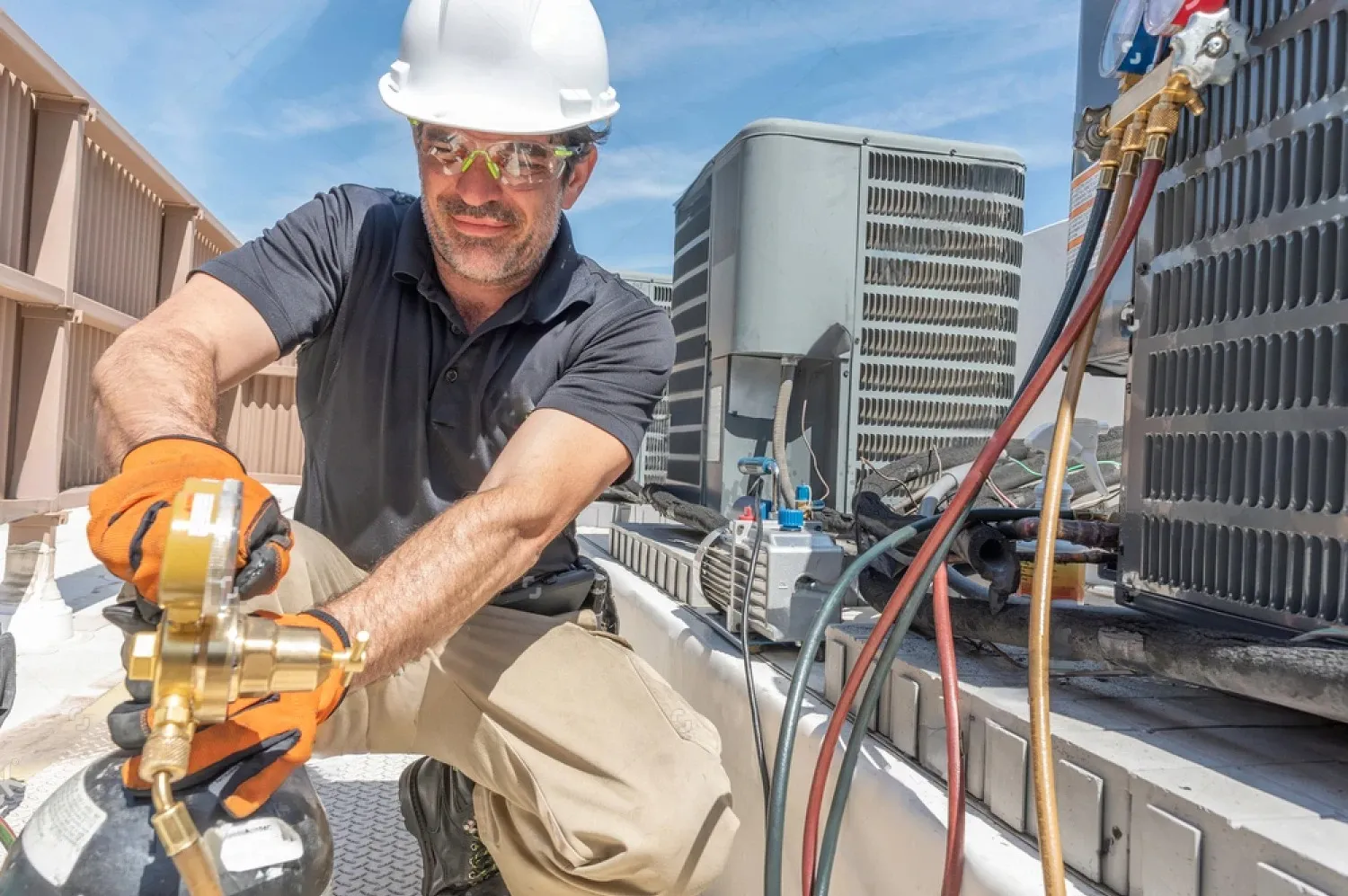 HVAC technician checking air conditioning unit with safety equipment
