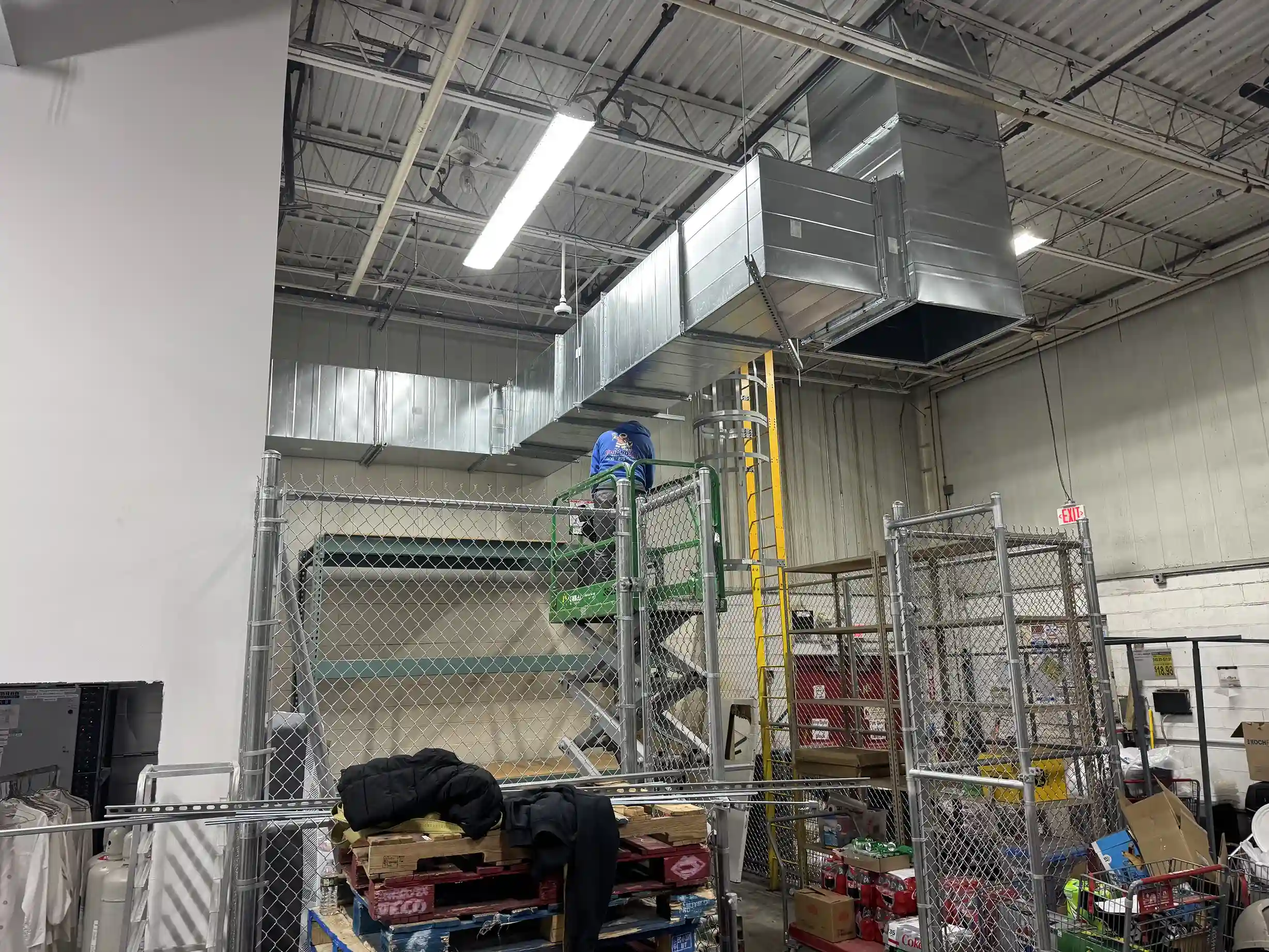 Industrial ductwork system with insulation and protective grill in mechanical room