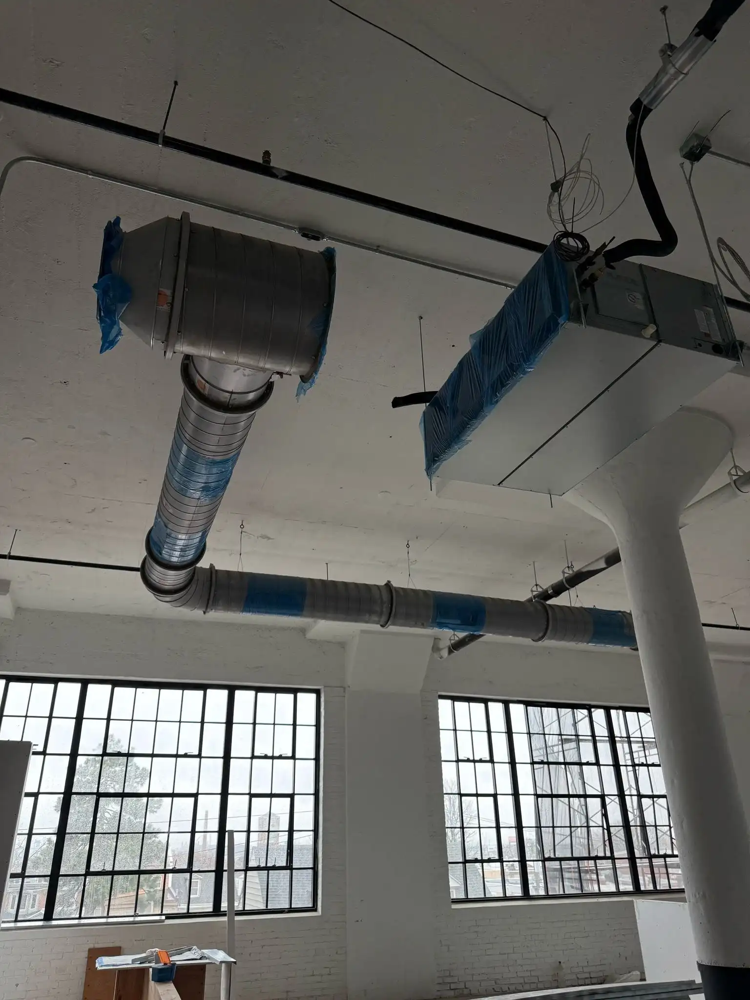 Suspended duct system with blue straps and nearby window