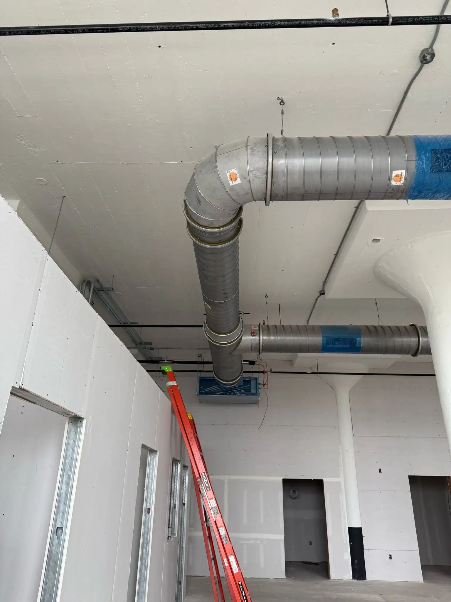 Large curved duct connected to ceiling ventilation system in progress