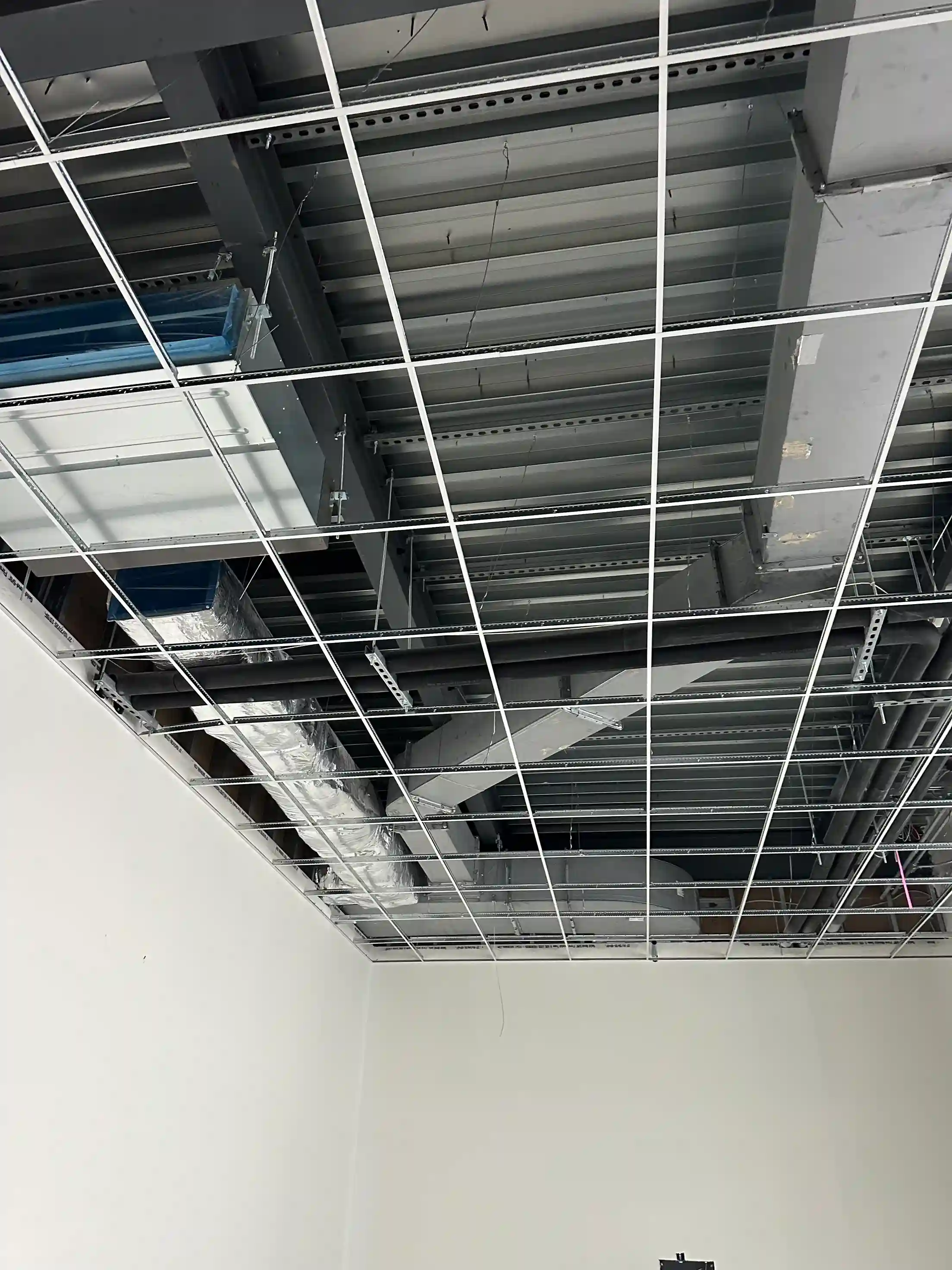 Partially completed ceiling HVAC duct network with framing visible