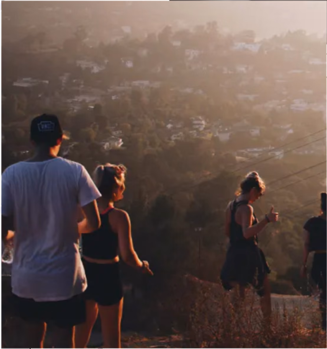 Friends watching the sunset over hillside houses