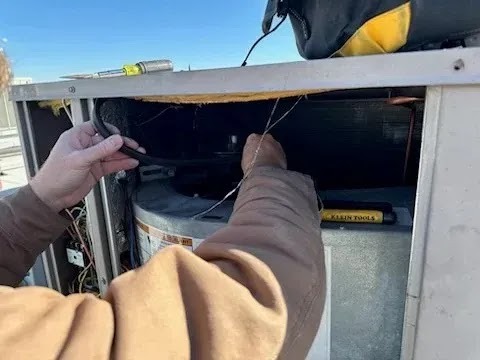 HVAC technician using electronic leak detector for AC refrigerant leak repair