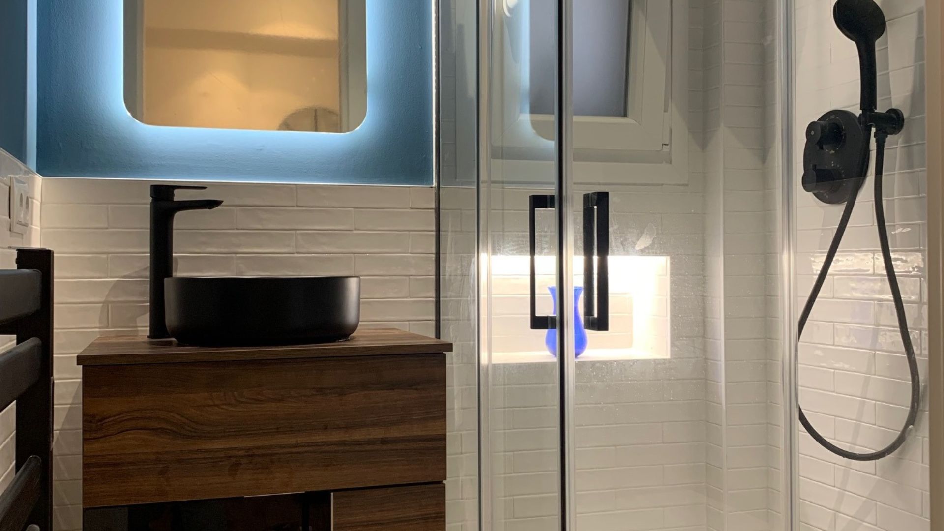  Baño terminado con mueble de lavabo, espejo iluminado y ducha integrada