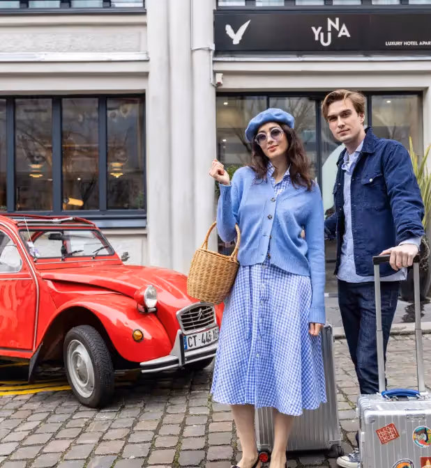 Couple posing in front of the facade of the hotel residence for long-term rental, Yuna.