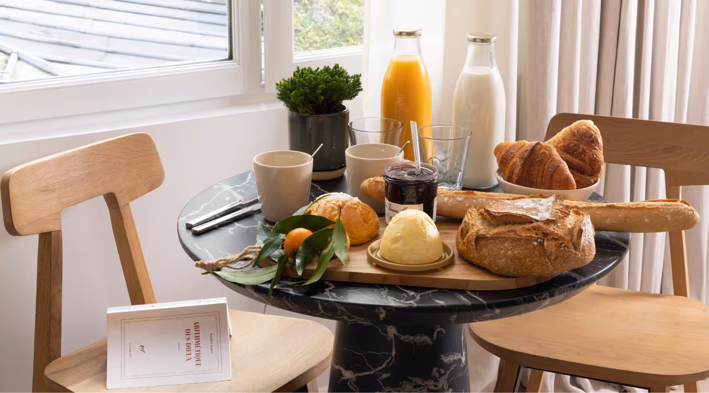 Table dressée avec petit déjeuner dans un appart hôtel meublé en location courte durée, Yuna.