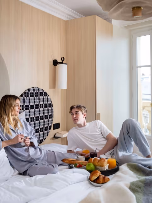 Couple having breakfast in bed in a furnished apartment hotel for long-term rental, Yuna.