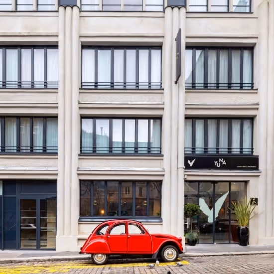 Voiture rouge devant Yuna Montmartre, résidence hôtelière avec appartement meublé à louer pour séjour affaires ou courte durée.
