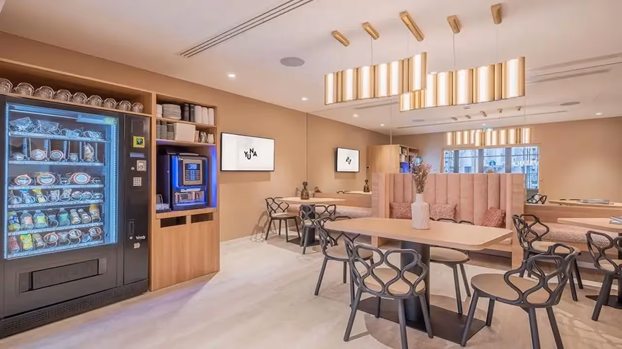 Tables with coffee and vending machines in a hotel residence for business stays and mobility leases, Yuna.