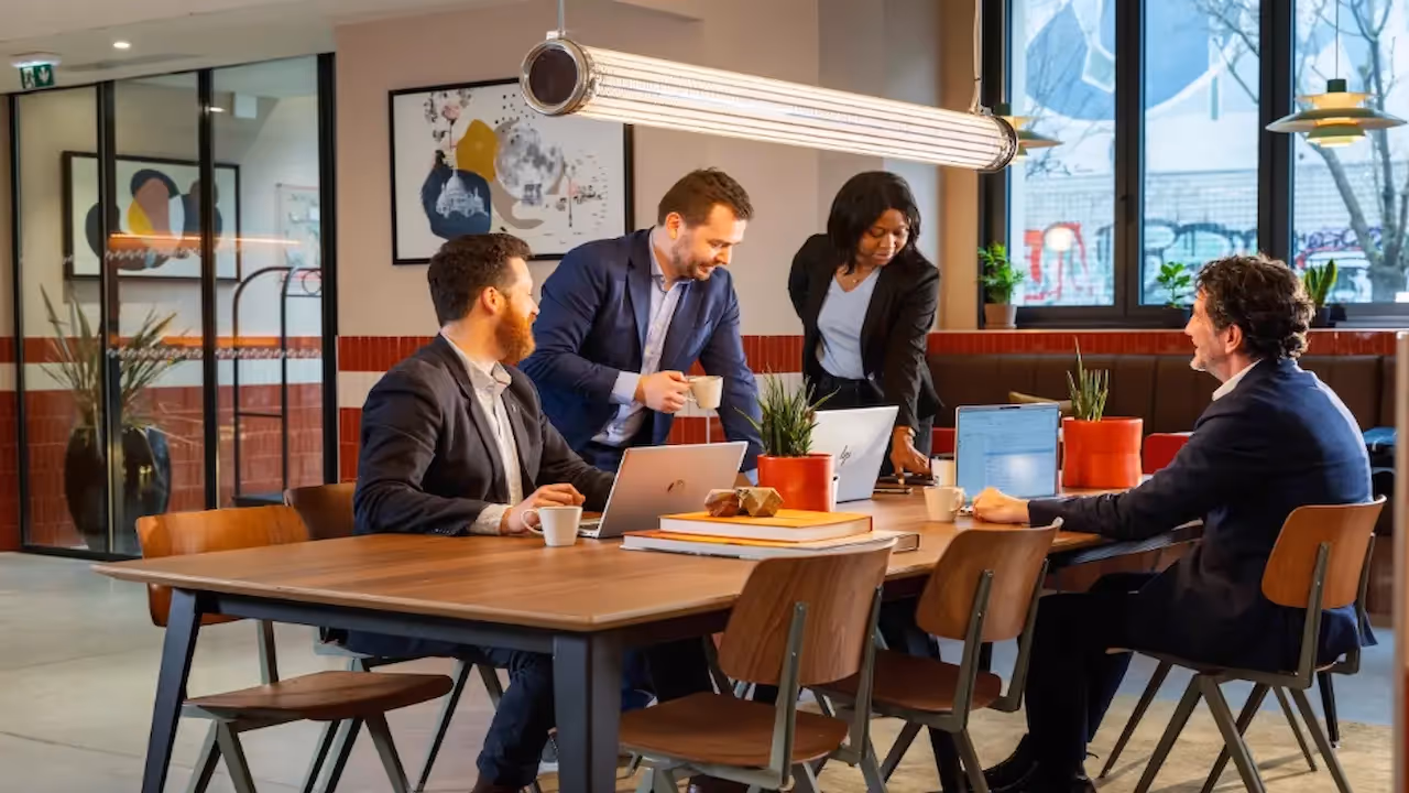 People working together around a table in a furnished apartment for business and corporate housing, Yuna.