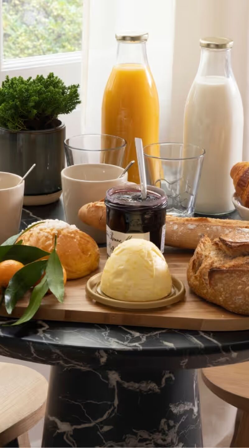Table dressée avec petit déjeuner dans un appart hôtel meublé en location courte durée, Yuna.