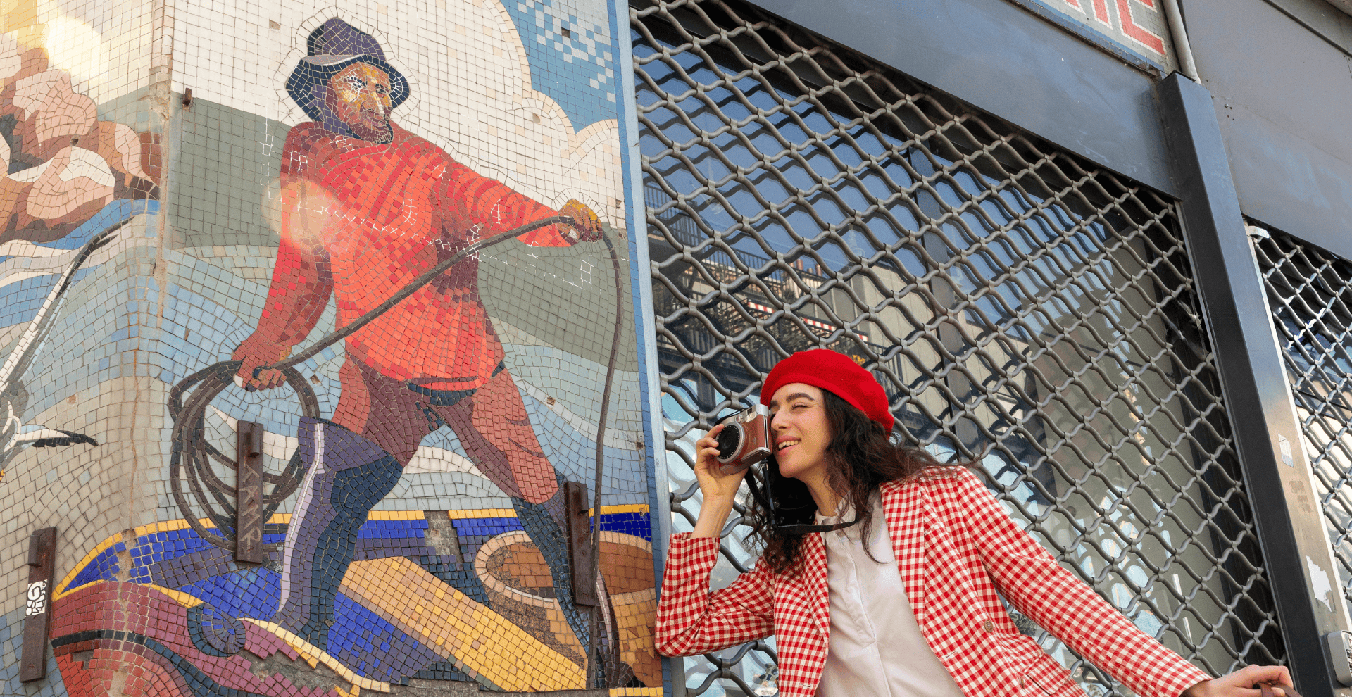 Femme avec béret rouge photographiant une mosaïque “Poissonnerie” à Montmartre, Paris